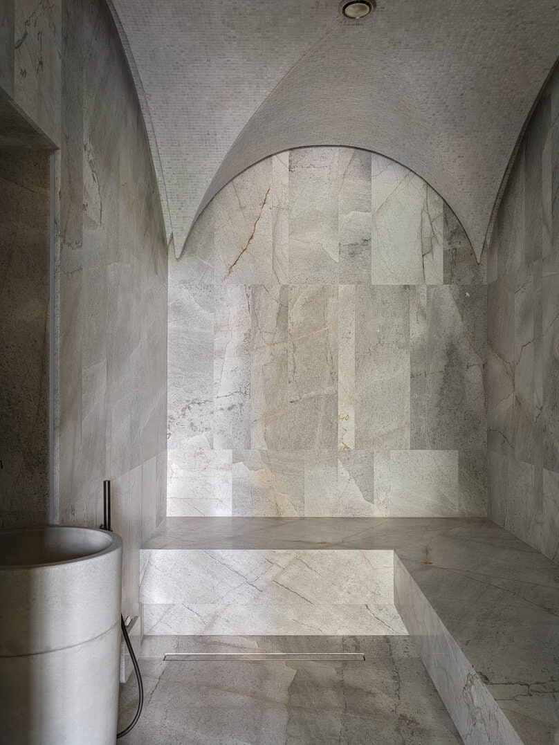 Spa or steam room with arched mosaic ceiling and stone tiled interior.