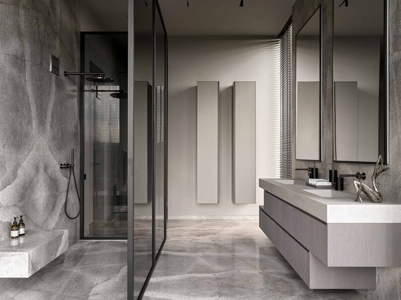 Modern shower design with textured marble walls and matte black fixtures.
