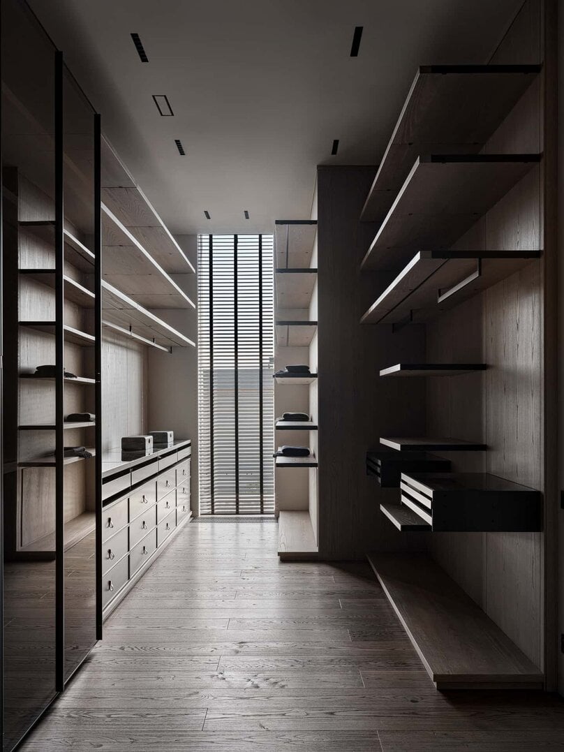 Spacious walk-in closet with open wooden shelving and floor-to-ceiling mirror.