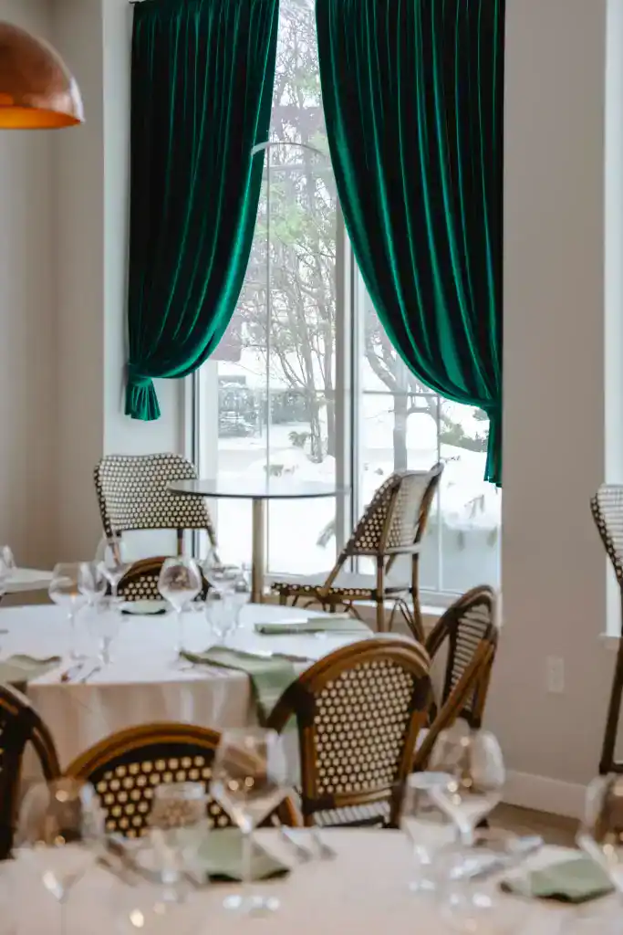 Cozy dining area with elegant green curtains at The Ember Room.