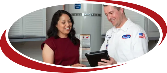 A background-checked Bell Brothers tech in a white uniform reviews upfront pricing with a customer, backed by our No Surprise Guarantee.