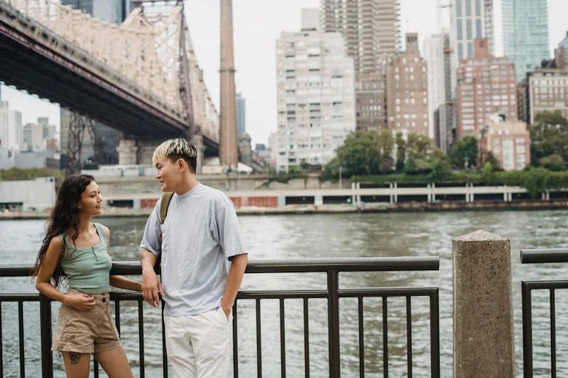 Young man talking with a woman on NYC , symbolizing a success hookups via apps.