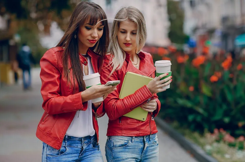 Persons using dating app on smartphone with urban city skyline in background