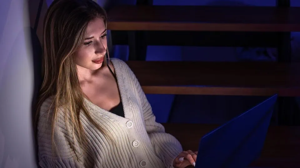 Person using laptop computer in modern home office exploring interactive online entertainment platform