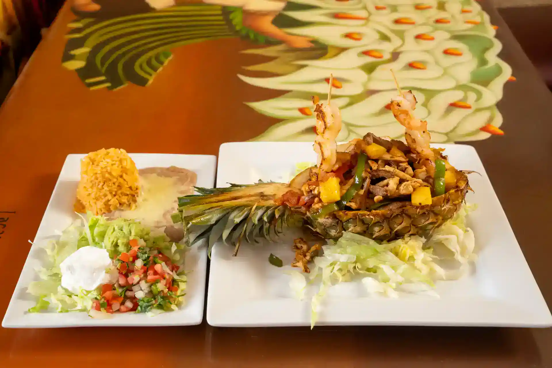 Delicious pineapple stuffed with shrimp and vegetables on a white plate.