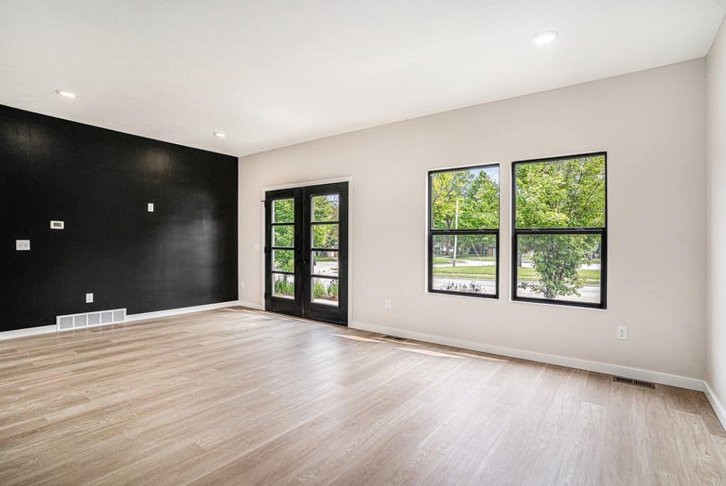 Bright living room with large windows and black accent wall.
