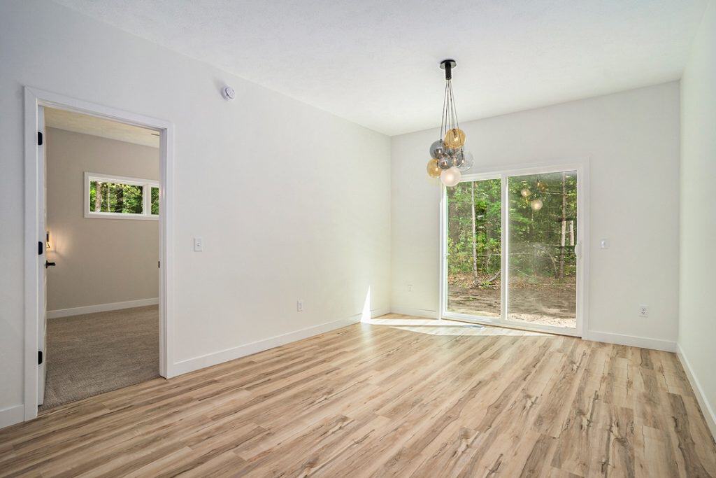 Bright living room with large sliding glass door and wood flooring.