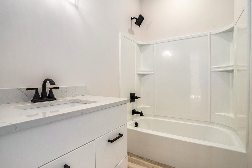Contemporary bathroom with bathtub, shower, and white cabinetry.