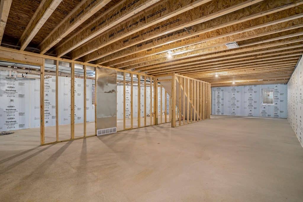 Unfinished interior of a custom home with exposed wooden framing and insulation.