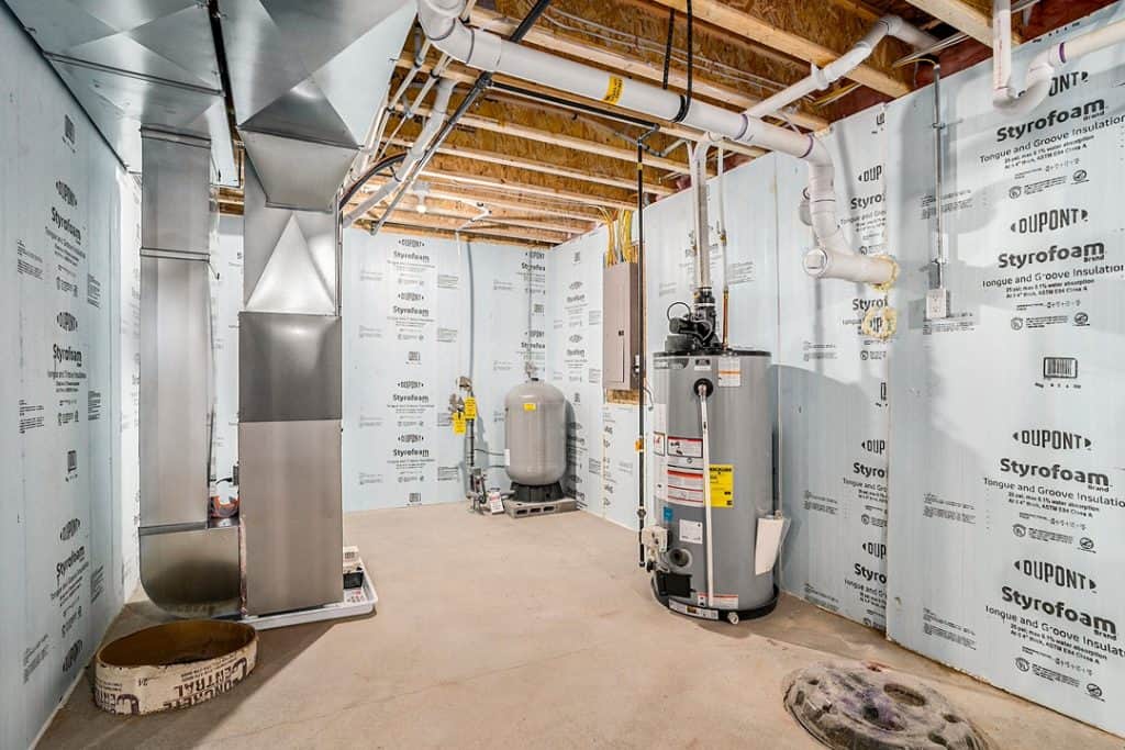 Interior view of a new home utility room with HVAC and plumbing systems.