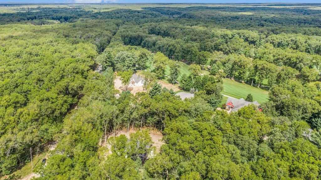 Aerial view of BuildWest Custom Homes property surrounded by lush greenery.