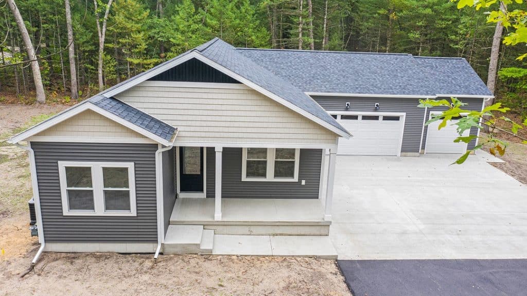 Contemporary custom home with gray siding and a spacious driveway.