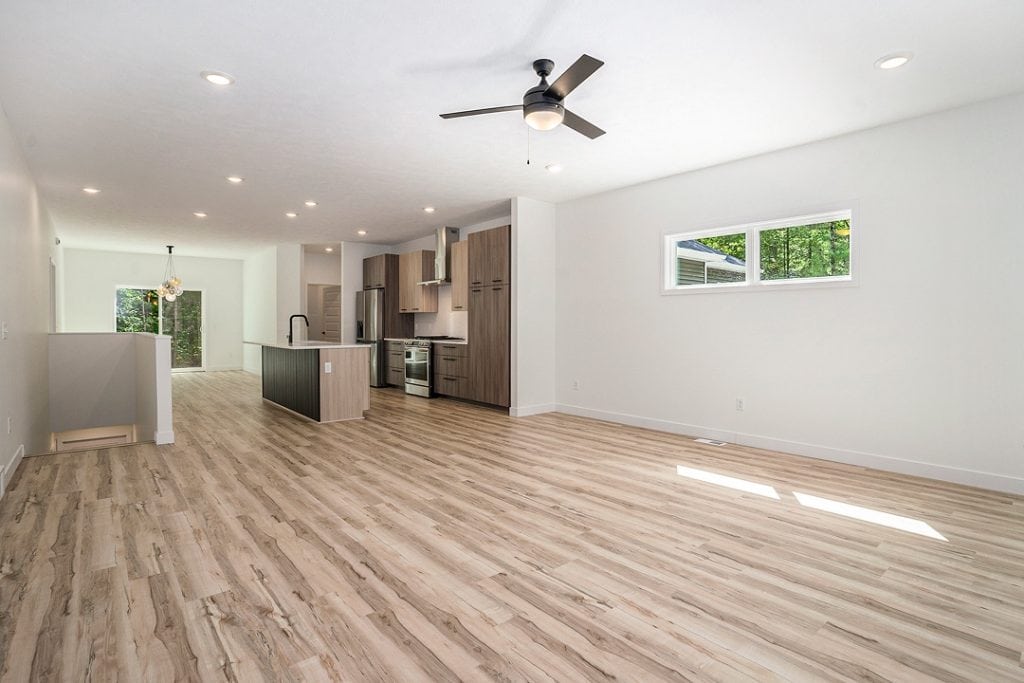 Spacious open-plan living area with kitchen and large window.