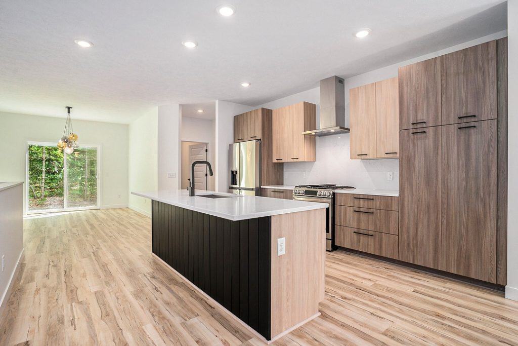 Contemporary kitchen with island, wooden cabinets, and stainless steel appliances.