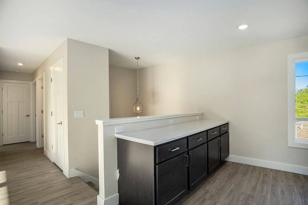 Contemporary kitchen with dark cabinetry and white countertops.
