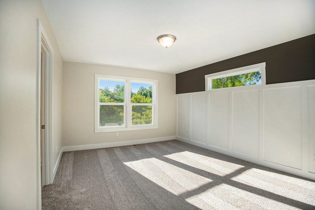 Bright interior room with large windows and neutral decor for home living.