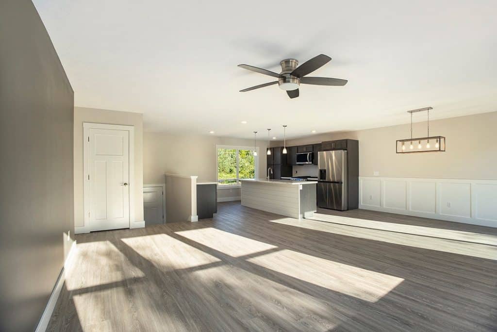 Spacious modern kitchen and living room with natural light and contemporary design.