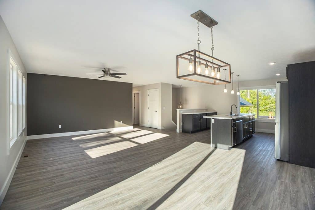 Spacious modern kitchen and living room with large windows and natural light.