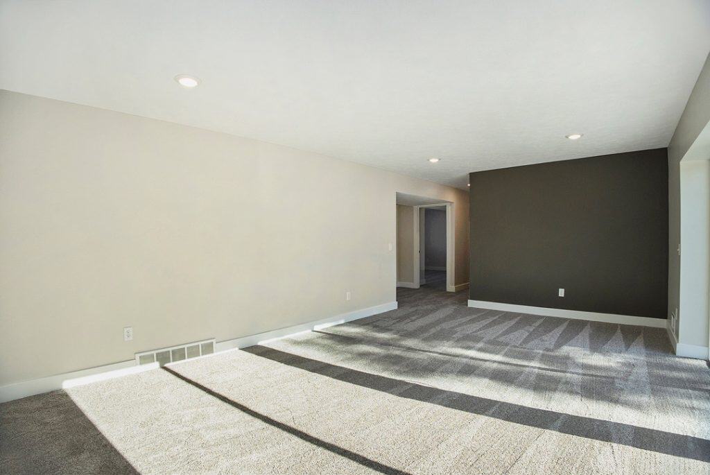 Bright, open living room with neutral walls and large windows.