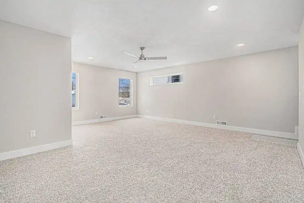 Bright, spacious living room with large windows and neutral decor by BuildWest Custom Homes.