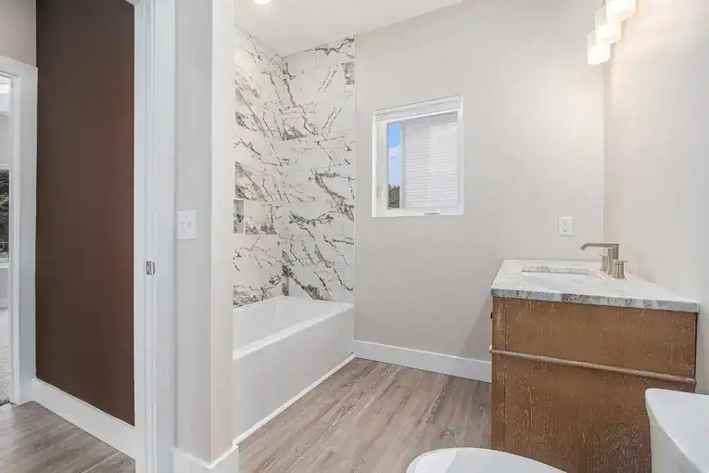 Contemporary bathroom with marble accents and natural light.