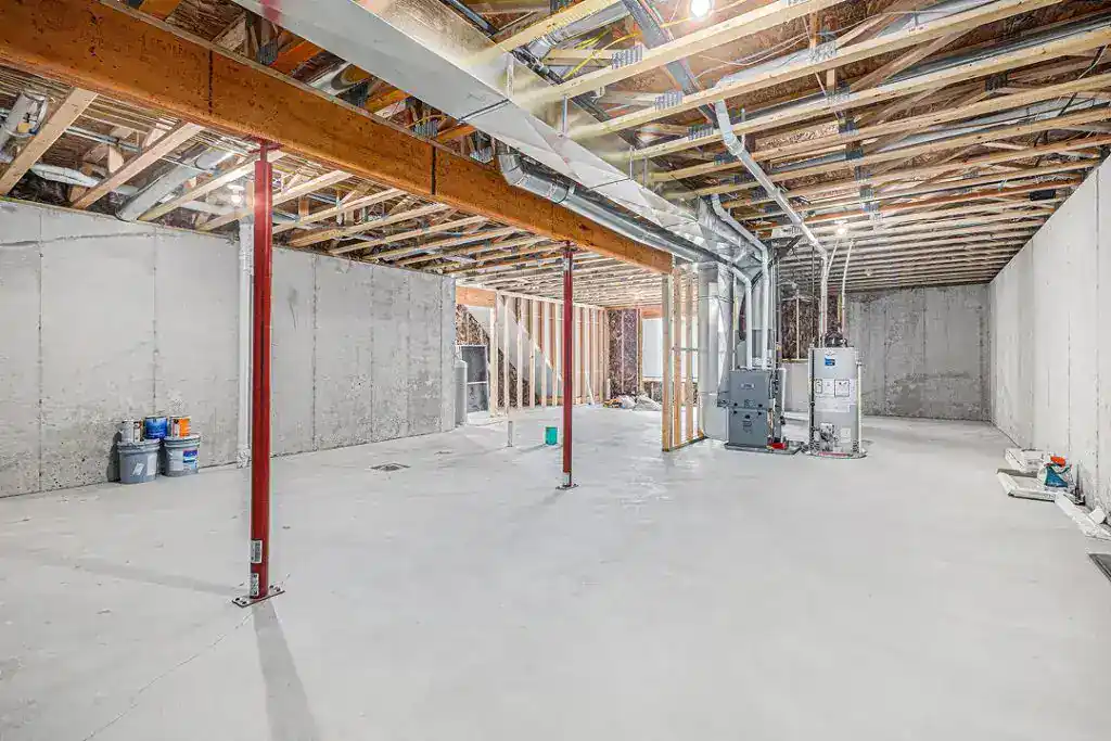 Interior view of a new home under construction with exposed framing and concrete floor.