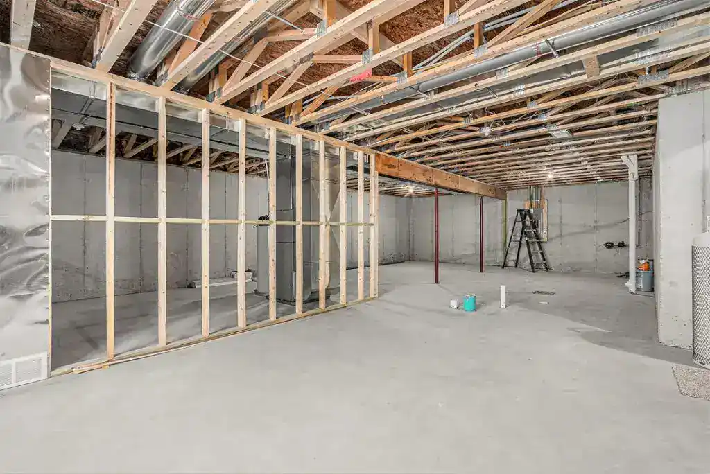 Interior view of a building under construction with framing and concrete floor.