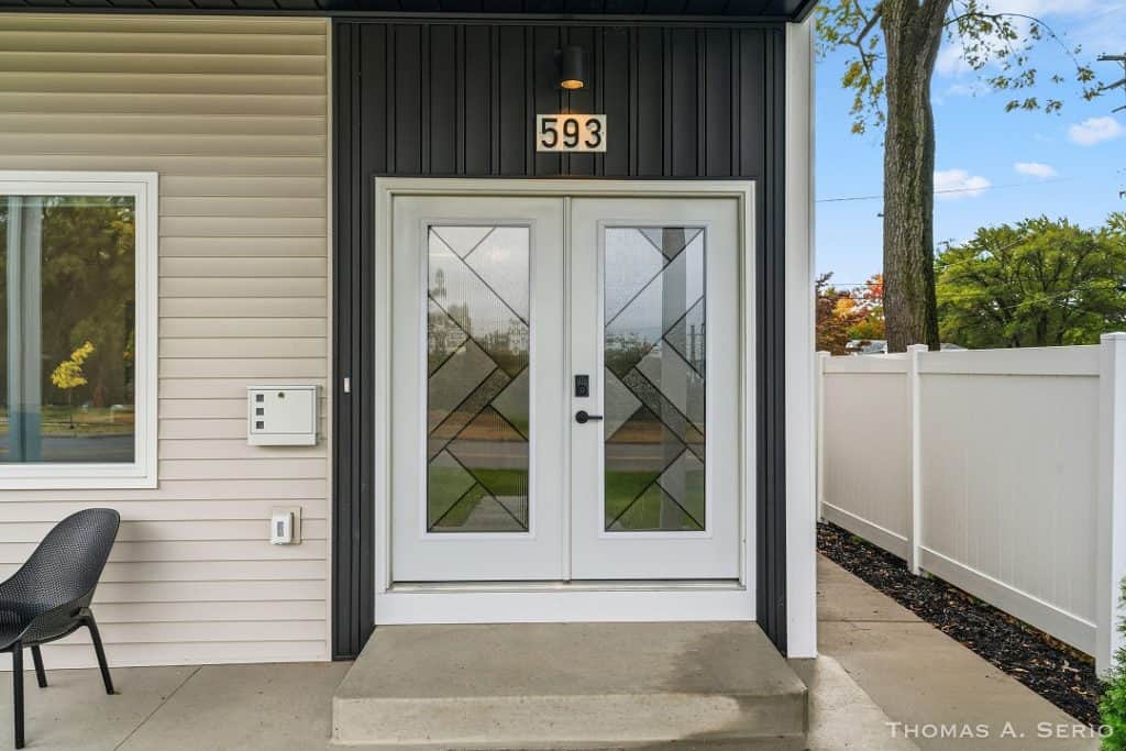 Contemporary home entrance with decorative glass door and house number 593.