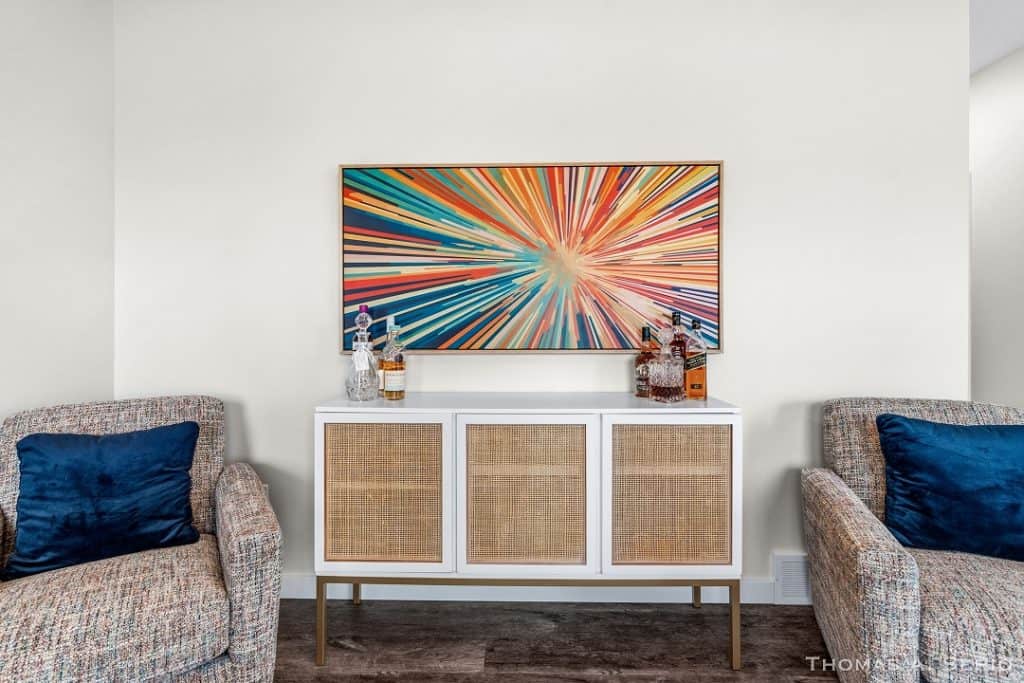 Contemporary living room with colorful abstract wall art and stylish furniture.