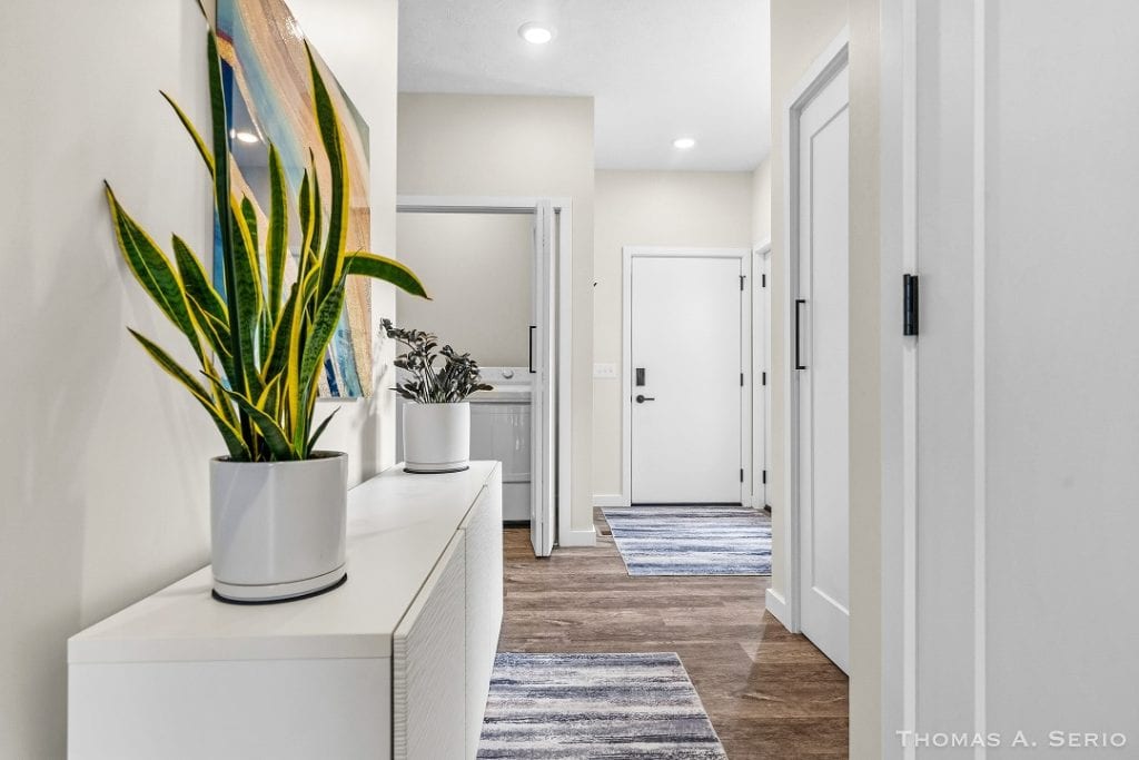 Bright modern hallway with white walls and wooden flooring.