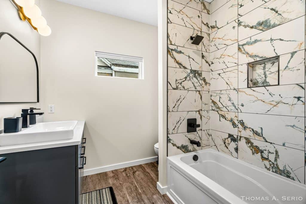 Contemporary bathroom featuring marble tile shower and sleek vanity.