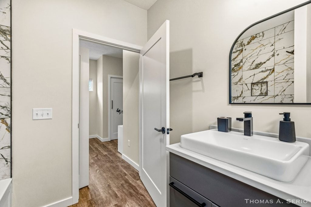 Contemporary bathroom with sleek sink and marble wall mirror.