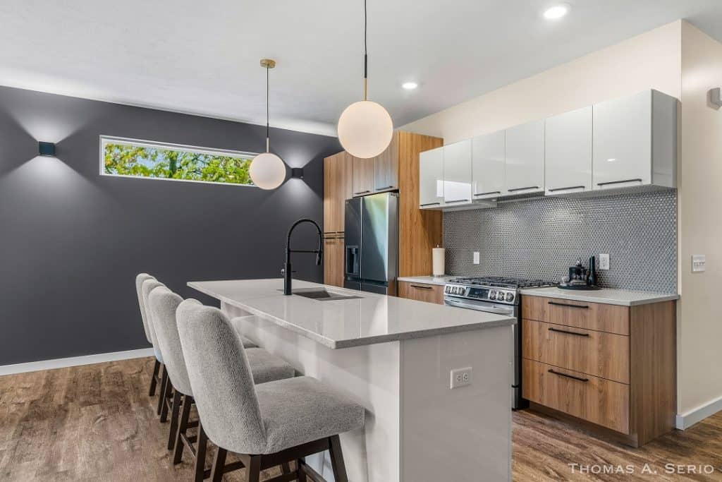 Contemporary kitchen with white cabinets, wooden accents, and a large island.