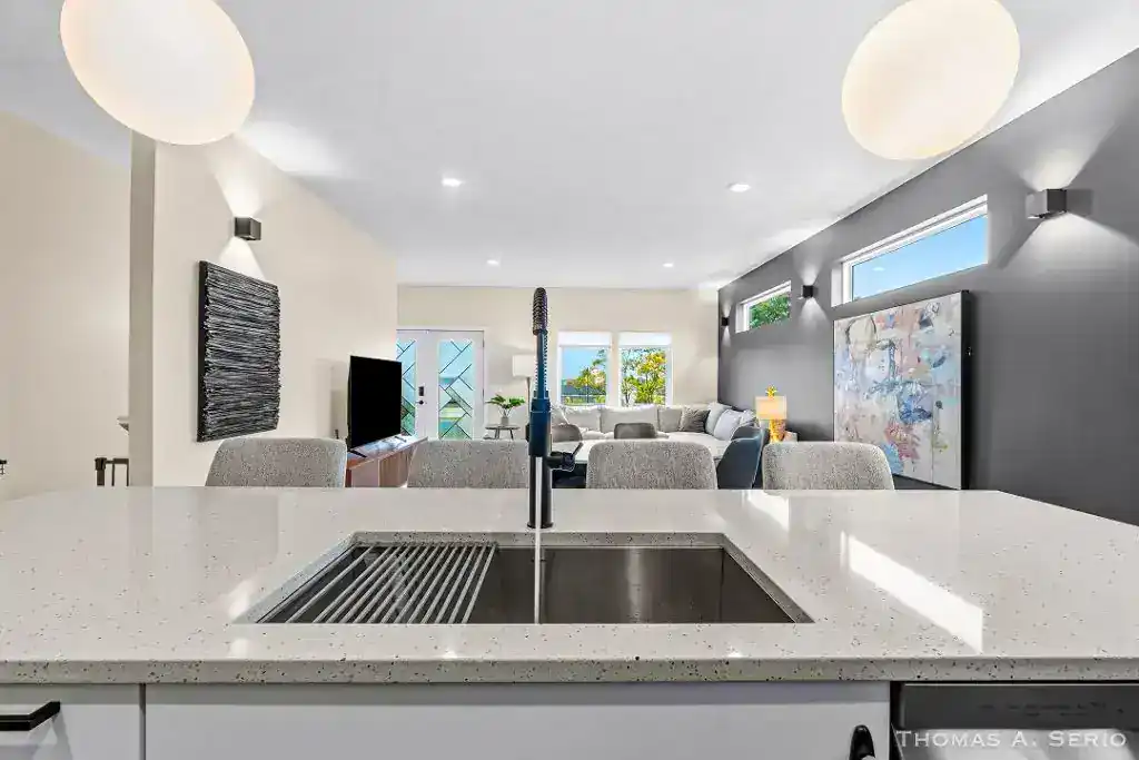 Spacious modern living room with open kitchen and large windows.