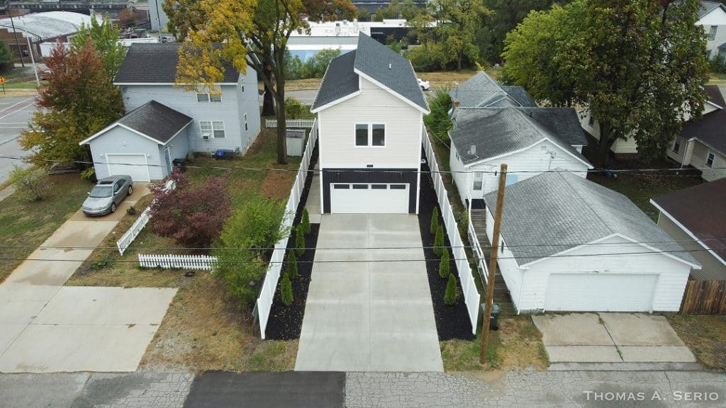 A modern two-story custom home with a spacious driveway and landscaped yard.
