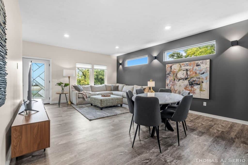 Spacious modern living room with gray walls, large windows, and contemporary furniture.