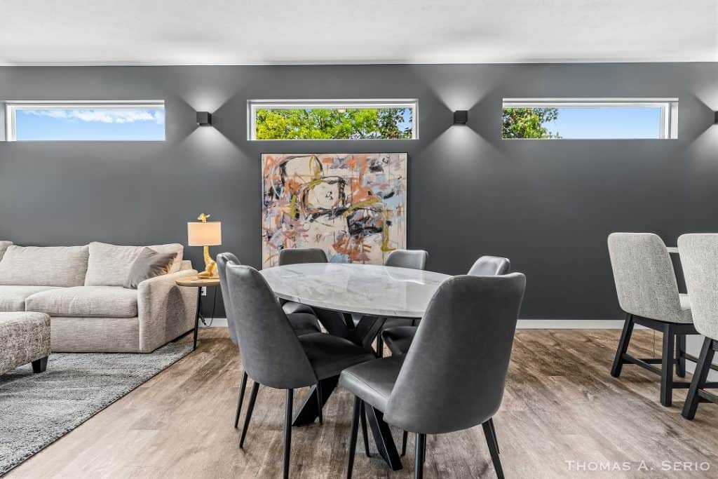 Contemporary dining room with gray chairs and abstract wall art.