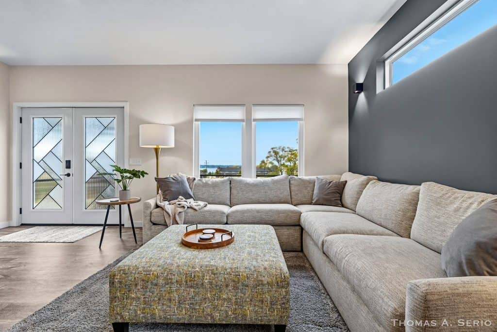 Bright living room with large windows and neutral furniture.