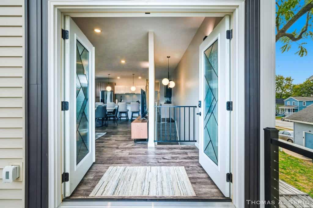 Open double doors leading to a stylish living space with dining area.