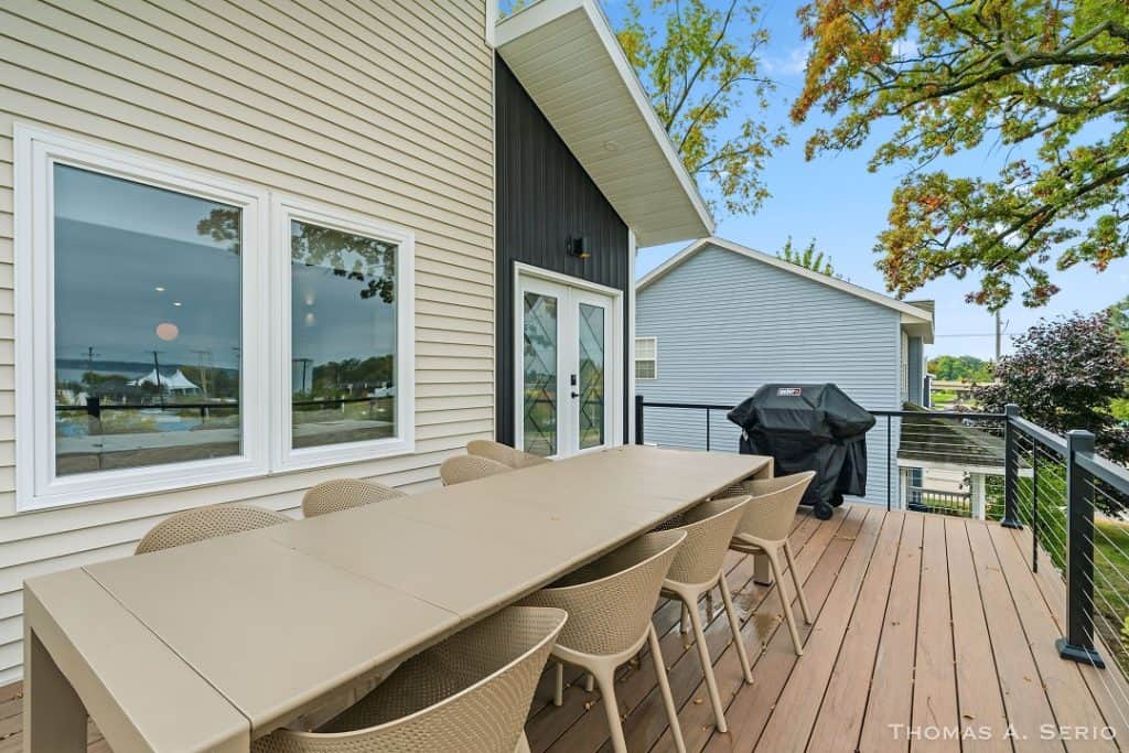 Outdoor deck with dining table and chairs at BuildWest Custom Homes.