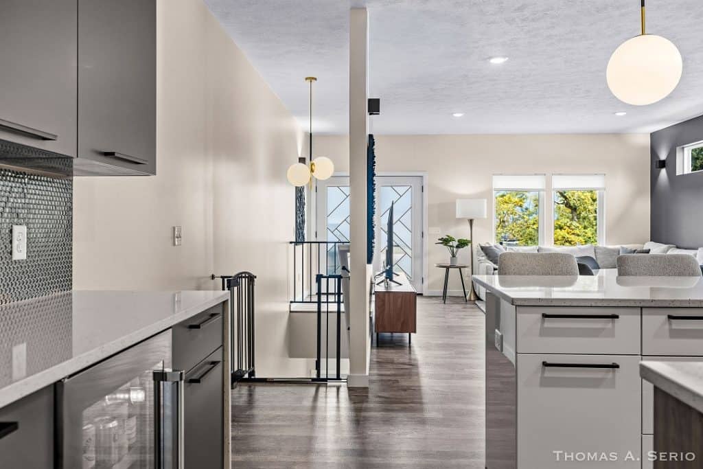 Spacious modern kitchen with open living area and large windows.