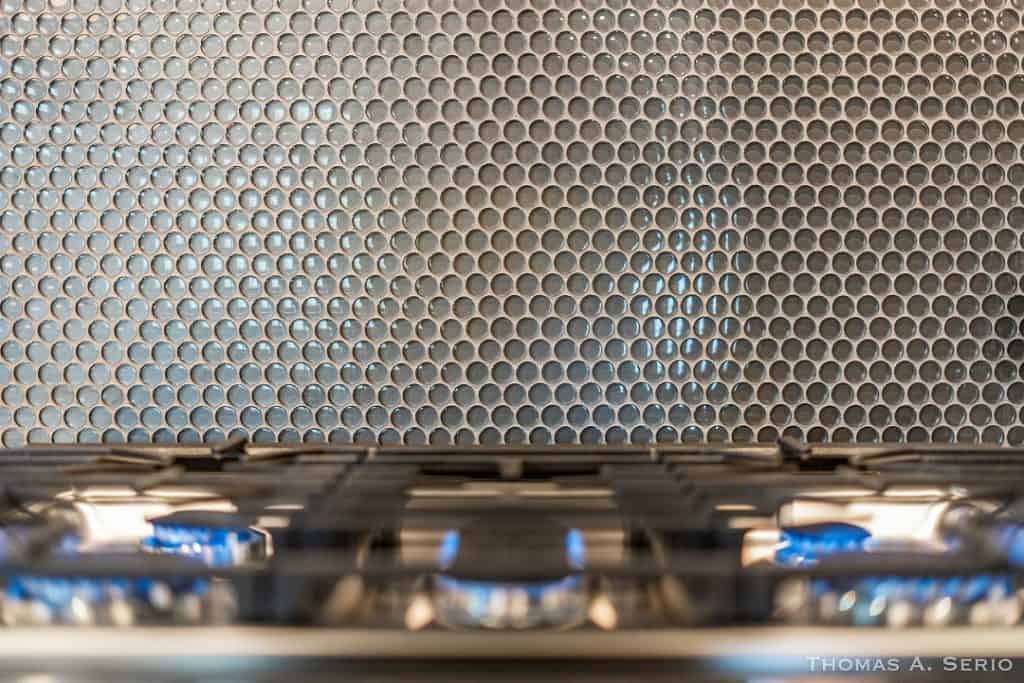 Close-up of a gas stove with blue flames and metal grate.