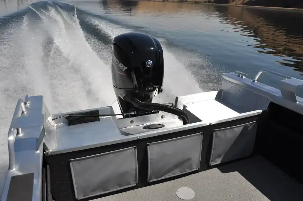 Boat with Mercury outboard motor on water, speed and wake visible.