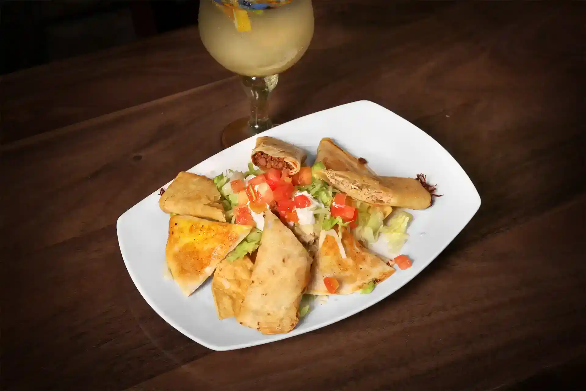 Delicious Mexican appetizers with crispy taquitos, fresh salsa, and a refreshing drink.