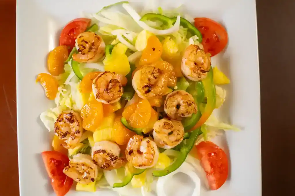 Delicious shrimp and fresh vegetable salad with tomatoes, lettuce, and citrus slices served at Casa.
