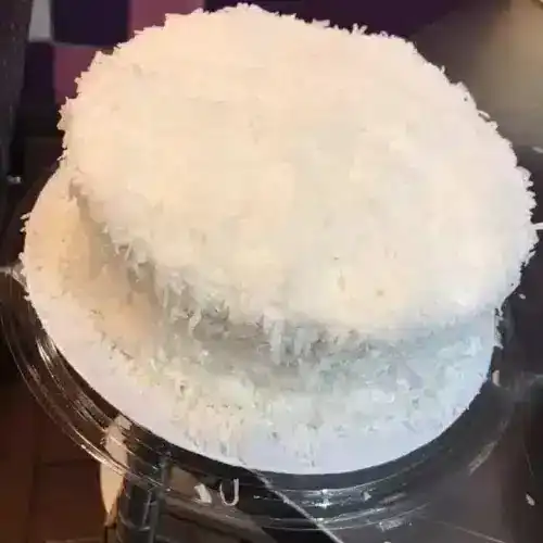 Delicious coconut cake with shredded coconut topping, perfect for celebrations.