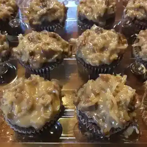 Delicious German Chocolate cupcakes topped with rich coconut-pecan frosting, perfect for special occasions or sweet cravings. Freshly baked by Corine's Soul Food, Cakes & Catering.