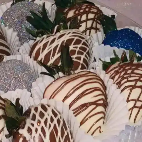 Assorted strawberries dipped in chocolate with decorative drizzles and sprinkles, perfect for desserts or special occasions.
