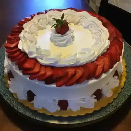 An elegant strawberry shortcake with fresh strawberries and whipped cream, perfect for celebrations.