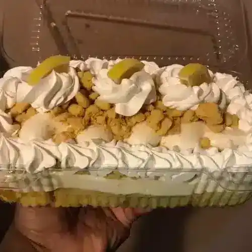 Delicious Lemon Delight cake with whipped cream, lemon slices, and cookie crumbs, perfect for special occasions and desserts.